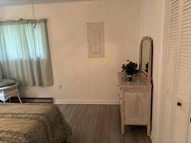 890 Gordon Way, Montross, VA 22520 - bedroom with electric panel, dark wood-type flooring, baseboards, and a baseboard heating unit