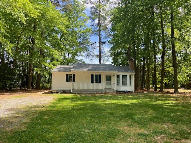 ranch-style house featuring covered porch and a front yard