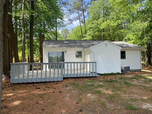 rear view of house featuring a wooden deck and central AC