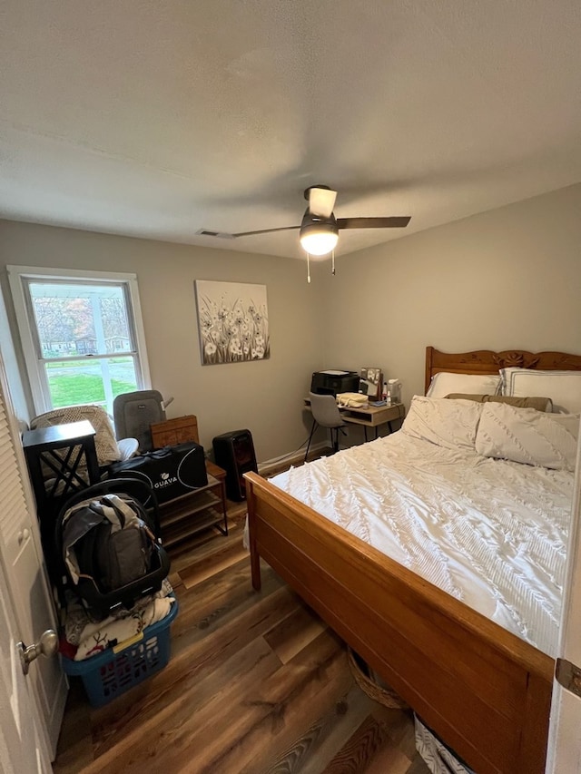 bedroom with ceiling fan and dark wood-type flooring