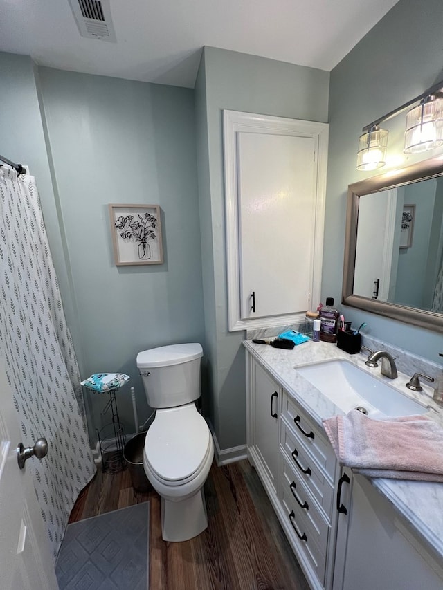 bathroom featuring hardwood / wood-style floors, vanity, and toilet