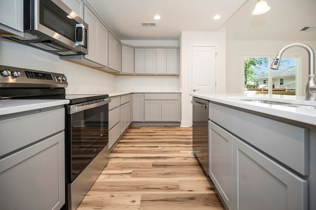 405 Cedar Ln, Colonial Beach, VA 22443 - kitchen with stainless steel appliances, gray cabinetry, light wood finished floors, light countertops, and recessed lighting
