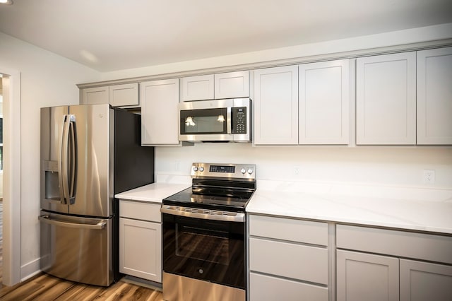 405 Cedar Ln, Colonial Beach, VA 22443 - kitchen featuring stainless steel appliances, gray cabinetry, wood finished floors, and light stone countertops