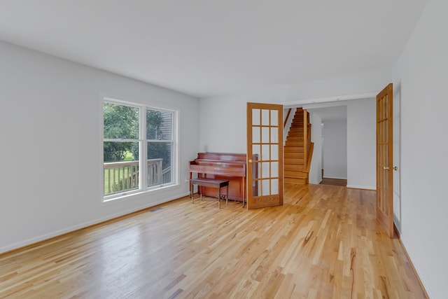 empty room with light wood-type flooring and french doors