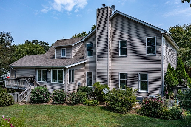 exterior space featuring a chimney, a wooden deck, stairs, and a lawn