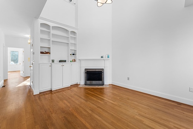 unfurnished living room featuring light hardwood / wood-style flooring and built in features