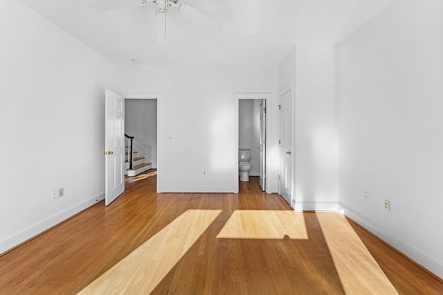 unfurnished bedroom with ceiling fan, light wood-type flooring, and connected bathroom