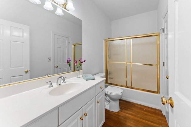 full bathroom with shower / bath combination with glass door, wood-type flooring, vanity, and toilet