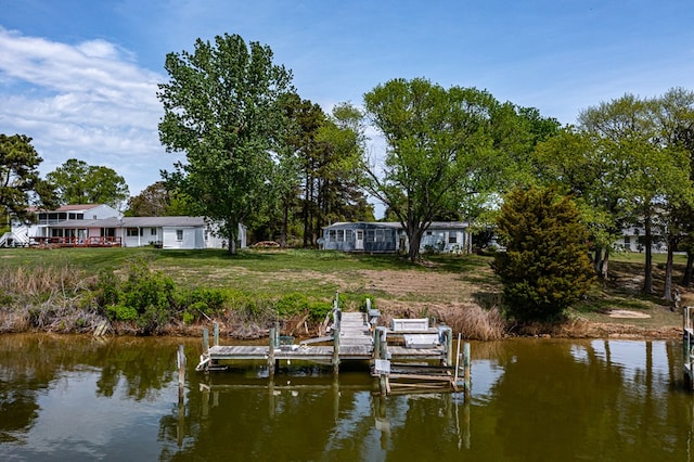 dock area featuring boat lift, a yard, and a water view