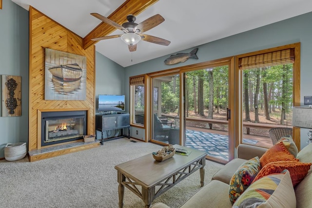 carpeted living room with ceiling fan, wood walls, a fireplace, and a wealth of natural light