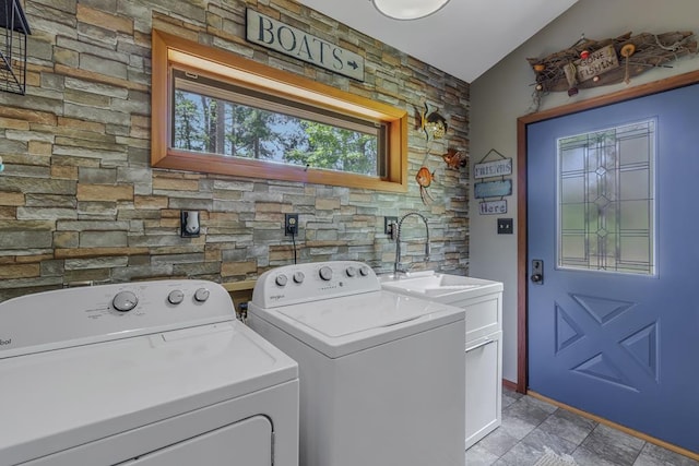 clothes washing area with washer and dryer, cabinets, and sink