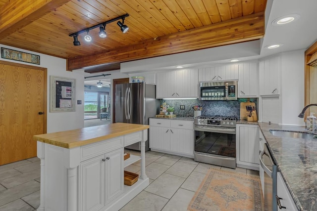 kitchen with track lighting, sink, tasteful backsplash, white cabinetry, and stainless steel appliances