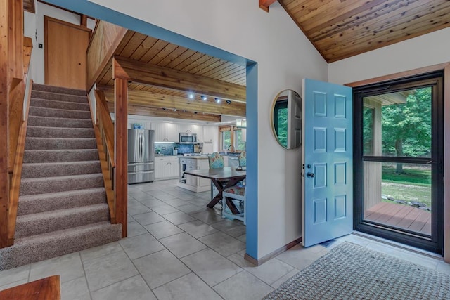 entrance foyer with beamed ceiling, plenty of natural light, wooden ceiling, and light tile patterned floors