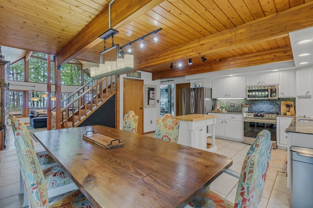 dining space with beam ceiling, light tile patterned floors, and wooden ceiling