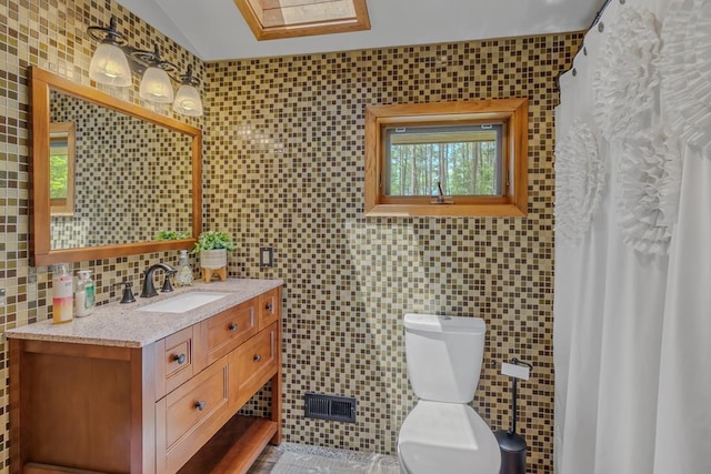 bathroom with tasteful backsplash, vanity, tile walls, and toilet