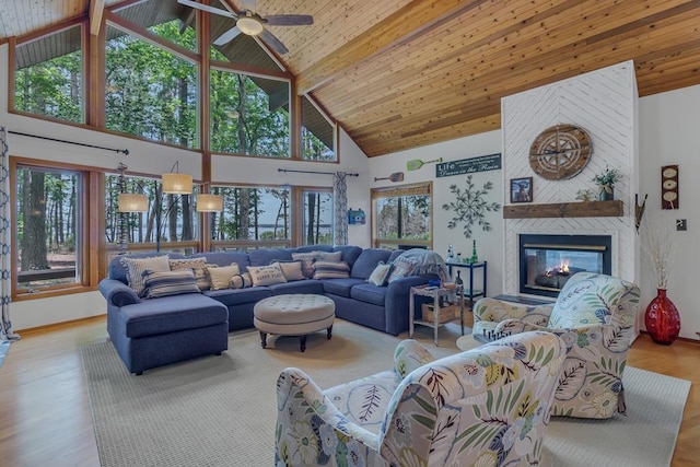 living room with beam ceiling, wood ceiling, a fireplace, and high vaulted ceiling