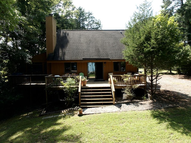 back of property with a lawn and a deck