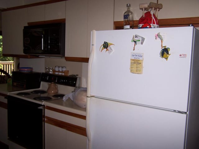 kitchen with white cabinets and white appliances