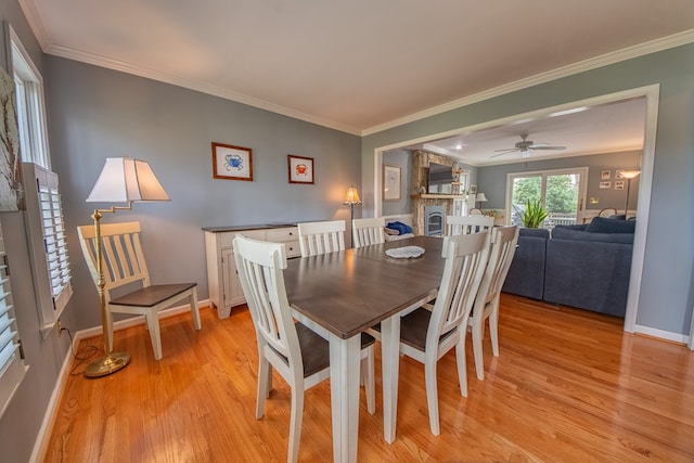 403 Moores Creek Dr, Deltaville, VA 23043 - dining space featuring light wood-style flooring, a fireplace, ornamental molding, baseboards, and ceiling fan