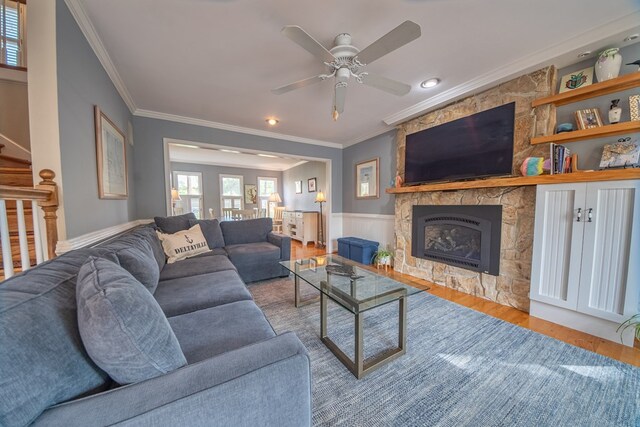 403 Moores Creek Dr, Deltaville, VA 23043 - living area with crown molding, wood finished floors, a stone fireplace, a ceiling fan, and wainscoting