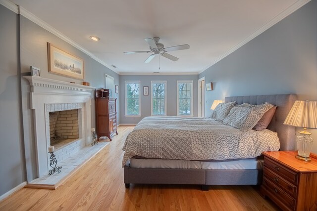 403 Moores Creek Dr, Deltaville, VA 23043 - bedroom with wood finished floors, baseboards, crown molding, a ceiling fan, and a fireplace
