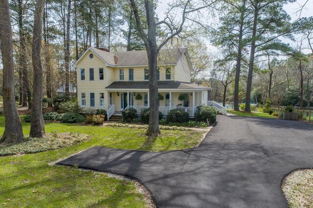 403 Moores Creek Dr, Deltaville, VA 23043 - view of front facade featuring a porch, a front yard, and asphalt driveway