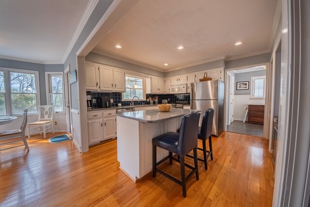 403 Moores Creek Dr, Deltaville, VA 23043 - kitchen with stainless steel appliances, healthy amount of natural light, light wood-style flooring, a sink, and crown molding