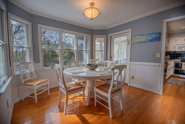 403 Moores Creek Dr, Deltaville, VA 23043 - dining space with light wood-style floors, wainscoting, and ornamental molding