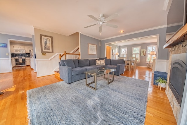 403 Moores Creek Dr, Deltaville, VA 23043 - living room featuring stairway, light wood-type flooring, ornamental molding, ceiling fan, and a wainscoted wall