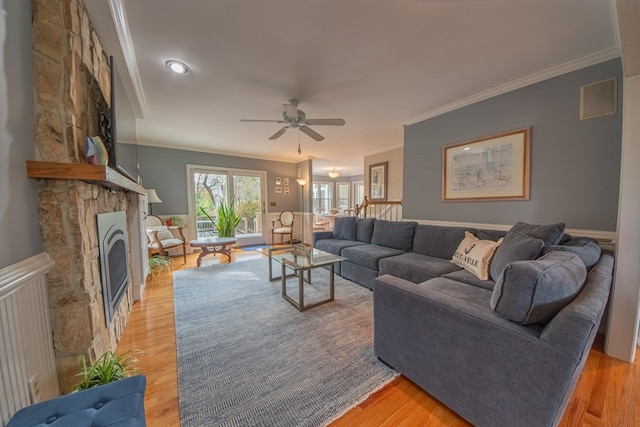 403 Moores Creek Dr, Deltaville, VA 23043 - living room with crown molding, a fireplace, ceiling fan, a wainscoted wall, and light wood finished floors
