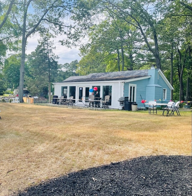 rear view of property featuring a yard