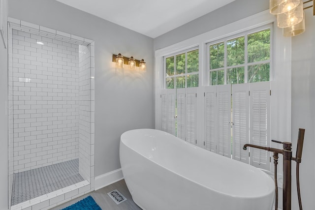 324 Bayberry Ln, Reedville, VA 22539 - bathroom featuring a freestanding bath, a tile shower, baseboards, and wood finished floors