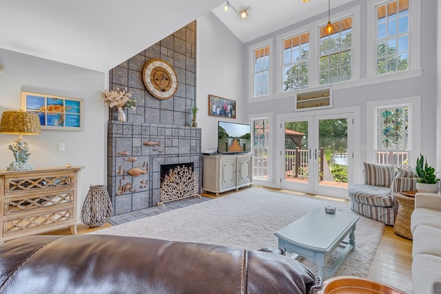 324 Bayberry Ln, Reedville, VA 22539 - living room with high vaulted ceiling, a tiled fireplace, wood finished floors, and french doors