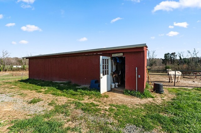 view of outdoor structure featuring fence and an outdoor structure