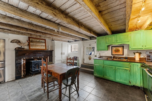 dining area with beamed ceiling, a wood stove, wood ceiling, and dark tile patterned floors