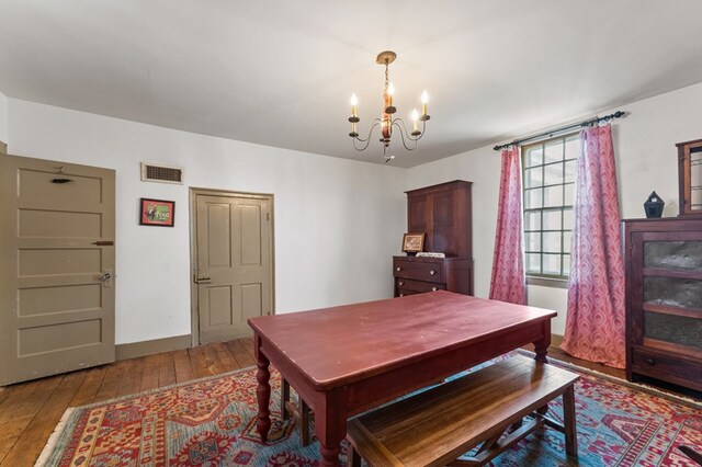 dining room featuring visible vents, hardwood / wood-style flooring, and a chandelier