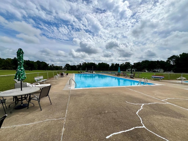 view of swimming pool with a patio area and a yard