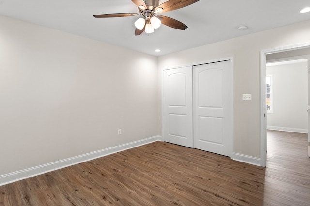 unfurnished bedroom with ceiling fan, a closet, and dark hardwood / wood-style floors