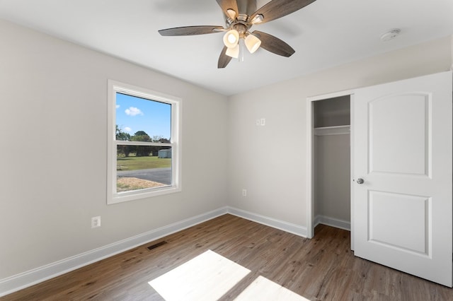 unfurnished bedroom featuring ceiling fan, a closet, and hardwood / wood-style floors