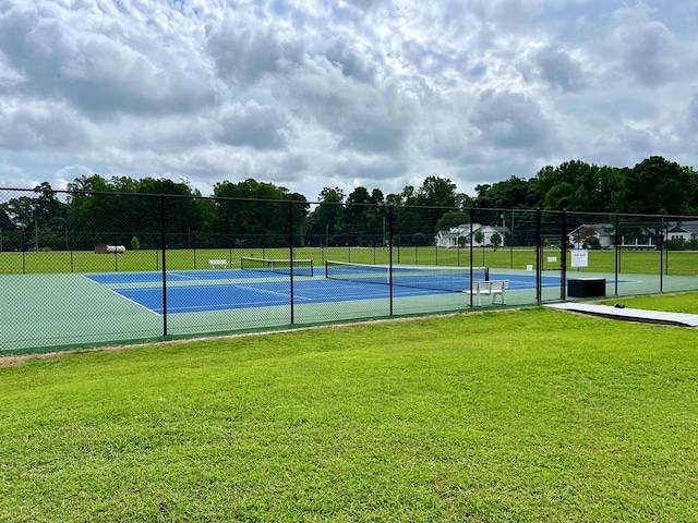 view of sport court with a lawn