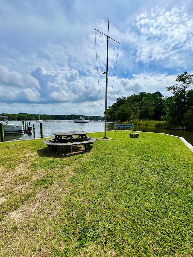 view of yard with a boat dock and a water view