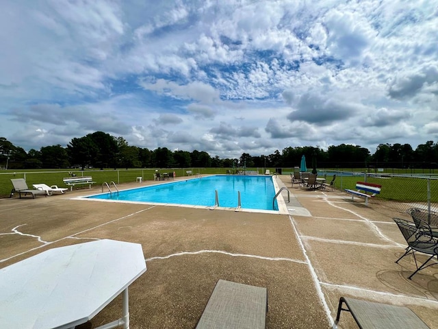 view of pool featuring a yard and a patio