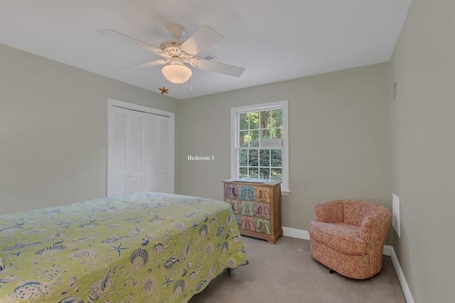 carpeted bedroom with ceiling fan and a closet