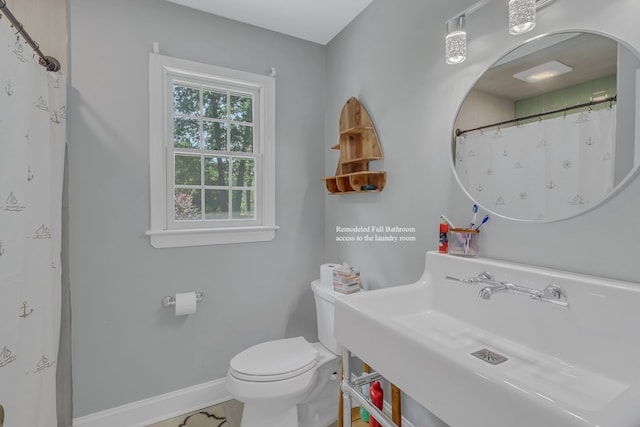 bathroom with toilet, sink, and walk in shower