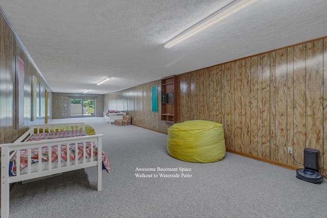 carpeted bedroom with wood walls and a textured ceiling