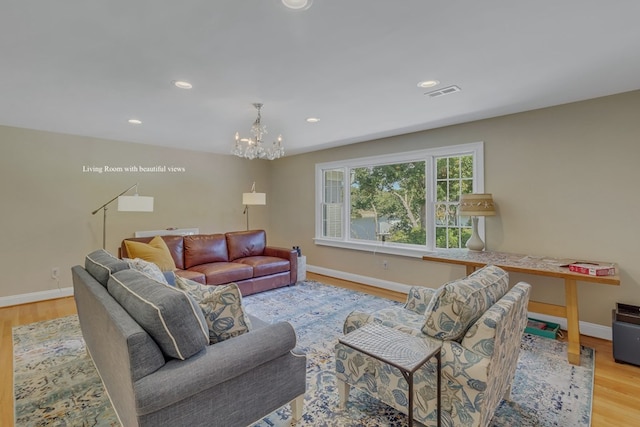 living room with light wood-type flooring and an inviting chandelier