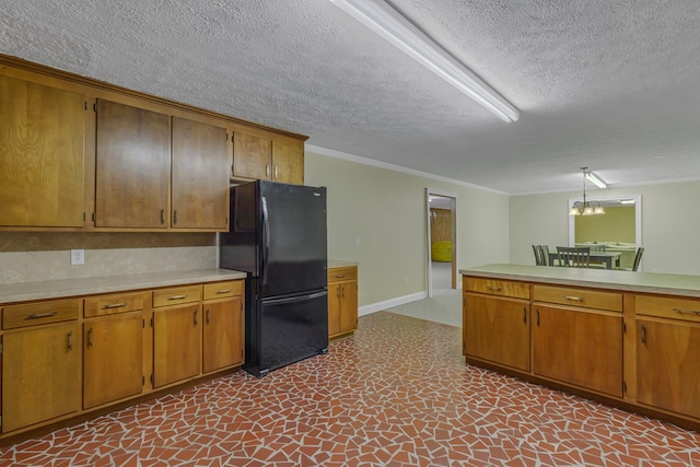 kitchen featuring black fridge, a notable chandelier, crown molding, a textured ceiling, and decorative light fixtures