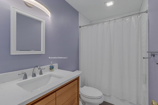 bathroom with a shower with shower curtain, vanity, and toilet