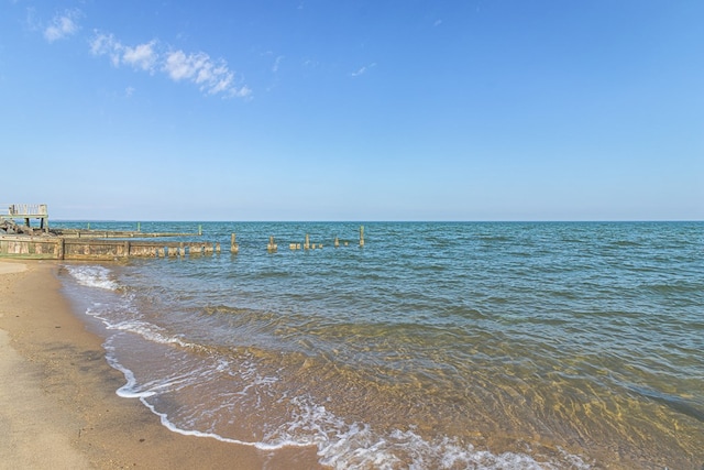 property view of water with a beach view and a dock