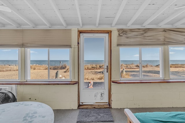 sunroom / solarium featuring a water view, a wealth of natural light, and beam ceiling